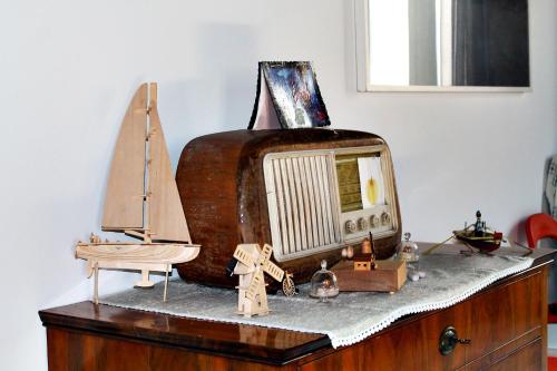 un viejo televisor sentado en la parte superior de un tocador con un bote de juguete en Il Mulino di Amleto - Bed and Breakfast letterario, en Molfetta