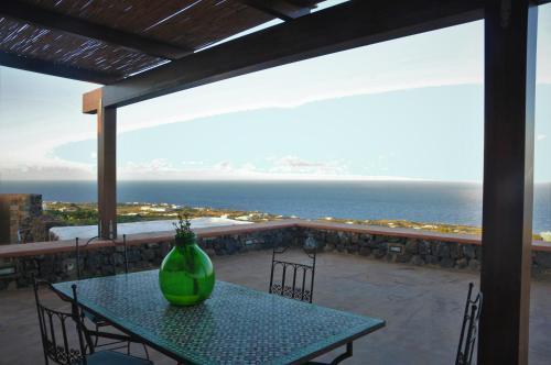 a green vase sitting on a table on a balcony at Horizon Pantelleria in Pantelleria
