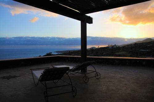 a couple of chairs sitting on a balcony with the ocean at Horizon Pantelleria in Pantelleria