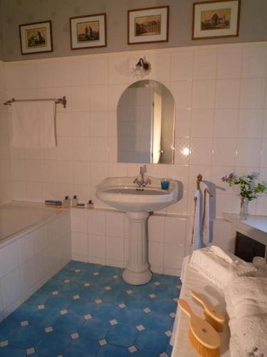 La salle de bains blanche est pourvue d'un lavabo et d'une baignoire. dans l'établissement Bed and Breakfast - Château du Vau, à Ballan-Miré