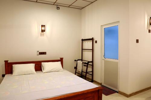 1 dormitorio con cama y ventana en Dearly Holiday Home And Safari, en Tissamaharama