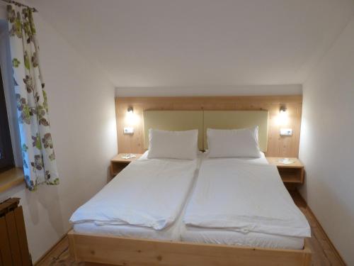 a bedroom with a large white bed with two pillows at Appartement Hauser in Stumm