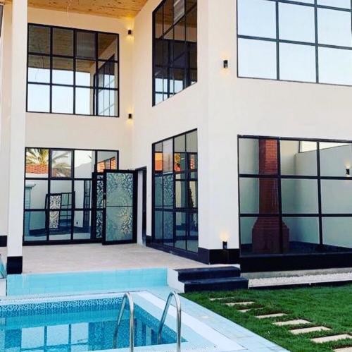 una casa con piscina frente a ella en فيلا بلاتنيوم اند كي ام, en Unaizah