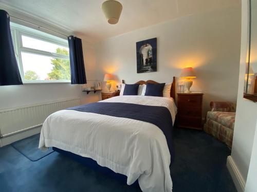 a bedroom with a large bed and a window at Masslink Guest House in Horley