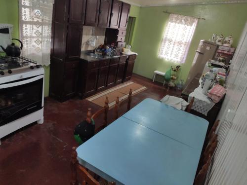a kitchen with a blue table and a stove at Casa de temporada da vovó in Urubici