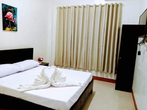 um quarto com uma cama com lençóis brancos e uma janela em Casa Loreta Hotel em Numancia