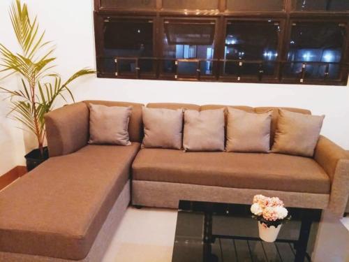 Sofá marrón en la sala de estar con mesa en Casa Loreta Hotel en Numancia
