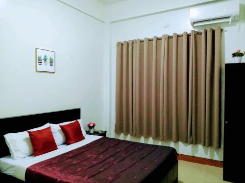 1 dormitorio con 1 cama grande con almohadas rojas en Casa Loreta Hotel en Numancia