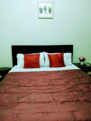 Una cama con dos almohadas rojas encima. en Casa Loreta Hotel, en Numancia