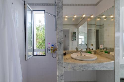 bagno con lavandino e specchio di STARBAL a Es Castell