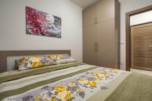 ズラティボールにあるApartman Gavrilov 3のベッドと壁に絵が飾られた寝室