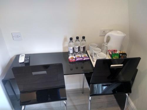 - un bureau noir avec des bouteilles de soda dans l'établissement NOX Olympia, à Londres
