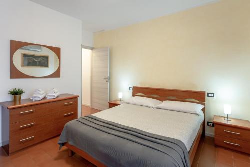 een slaapkamer met een bed, 2 dressoires en een spiegel bij Appartamenti Angelica Ospedale cisanello in Pisa