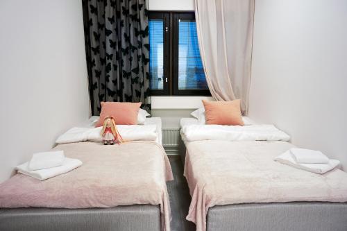 two beds in a room with a window at Inn Tourist Hostel in Helsinki
