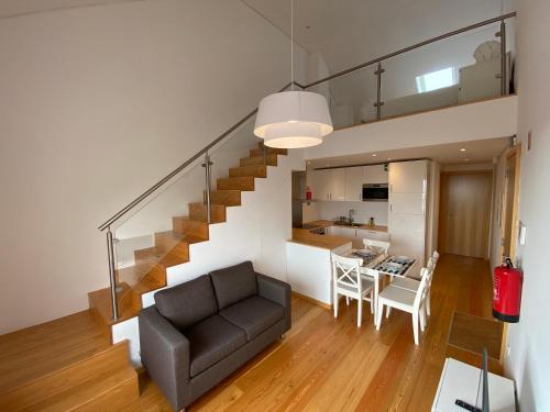 een woonkamer en een keuken met een bank en een trap bij Casa dos Remedios in Angra do Heroísmo