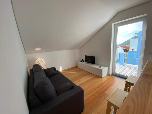 a living room with a couch and a large window at Casa dos Remedios in Angra do Heroísmo