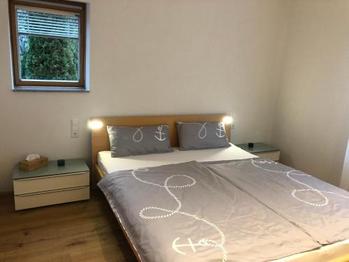 Schlafzimmer mit einem Bett mit weißer Bettwäsche und einem Fenster in der Unterkunft FeWo am Osthafen in Überlingen