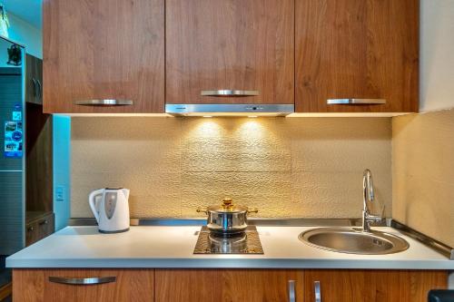 a kitchen with a sink and wooden cabinets at GVC 301 New Gudauri in Gudauri