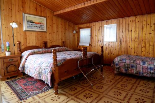 a bedroom with two beds in a wooden room at Albergo Mirella in Belluno