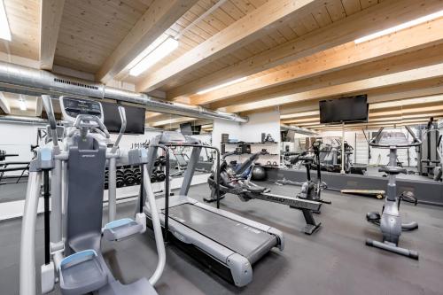 a gym with several treadmills and machines at SKI - GOLF - WELLNESS Hotel Riml in Hochgurgl