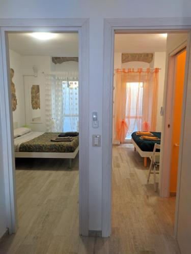 Pokój z 2 łóżkami i pokój z lustrem w obiekcie Green and Orange rooms w mieście Carloforte