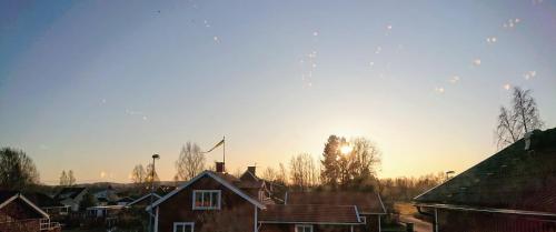a group of houses with the sun in the sky at Myntloftet Borlänge med inglasad bubbelbad in Borlänge