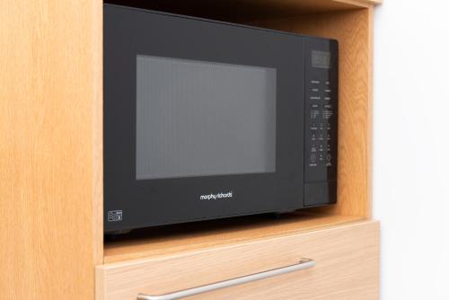 a microwave oven sitting inside of a cabinet at Soho Central Apartments in London