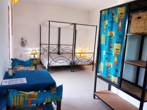uma sala com um quarto com uma cama e uma mesa em Cap-Sénégal em Cap Skirring