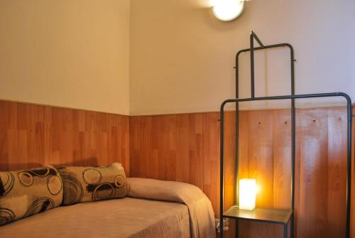 - une chambre avec un lit et une lampe à côté dans l'établissement Al Villino Sunrise appartamento in villa con piscina, à SantʼAlfio