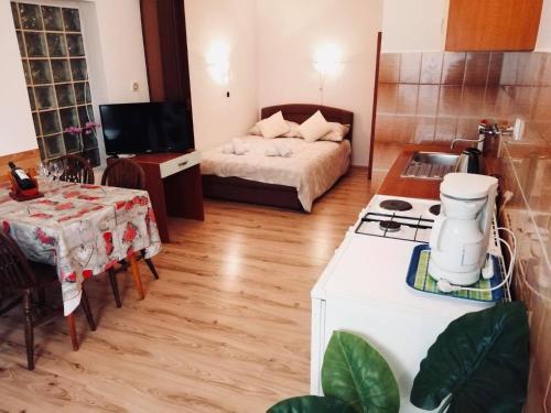 a kitchen and a living room with a bed and a table at Apartments Cizmesija in Baška