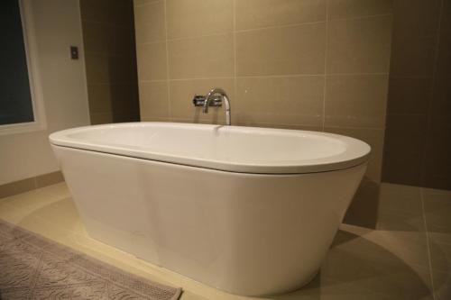 a white bath tub with a faucet in a bathroom at Docklands Luxury Penthouse Right Above The District Docklands in Melbourne