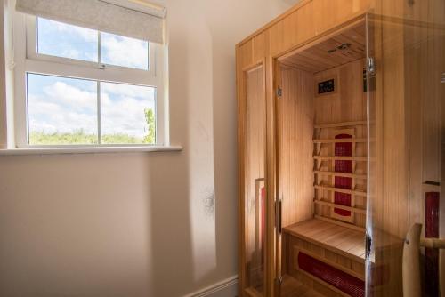 a walk in shower with a window in a bathroom at Doherty Farm Holiday Homes in Downings