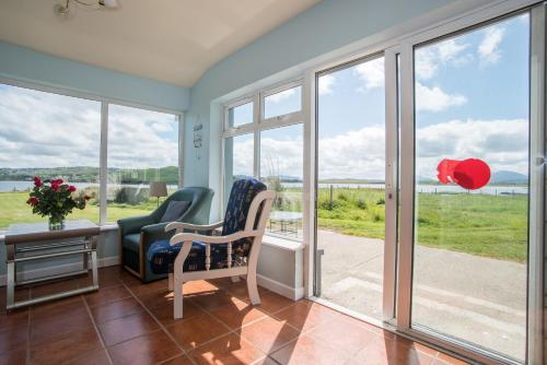 a room with two chairs and a table and windows at Doherty Farm Holiday Homes in Downings