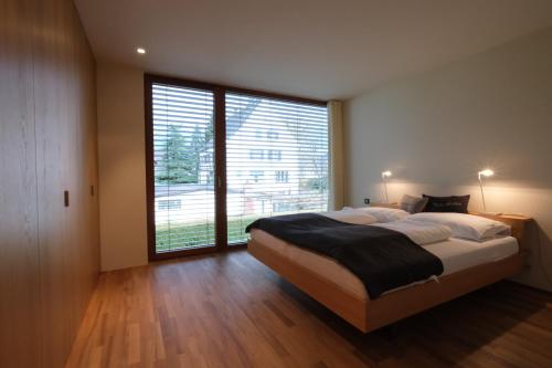 a bedroom with a large bed and a large window at Ferienhaus S11 Lustenau in Lustenau