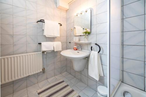 a white bathroom with a sink and a mirror at Ferienwohnungen Am Sonnenhang in Theisseil