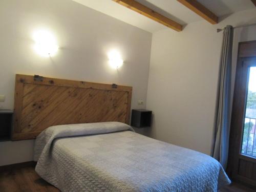 a bedroom with a bed with a wooden headboard at La Parra de Pepa in Cercedilla