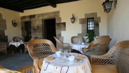 a restaurant with wicker chairs and tables in a room at Posada La Colodra in Los Tojos
