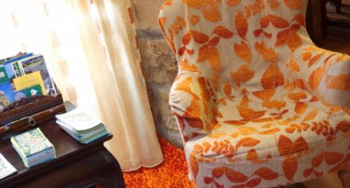a living room with a bed and a table with a pillow at Posada La Colodra in Los Tojos