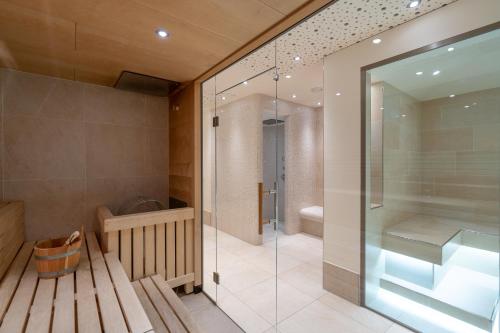 a bathroom with a glass shower and a toilet at VAYA Post Saalbach inklusive Joker Card in Saalbach Hinterglemm