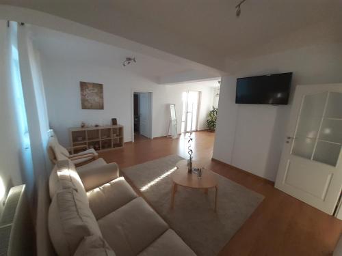 ein Wohnzimmer mit einem weißen Sofa und einem Tisch in der Unterkunft Casa Reds in Râmnicu Vâlcea