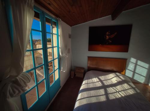 1 dormitorio con cama y ventana grande en At Home in Arles, en Arles