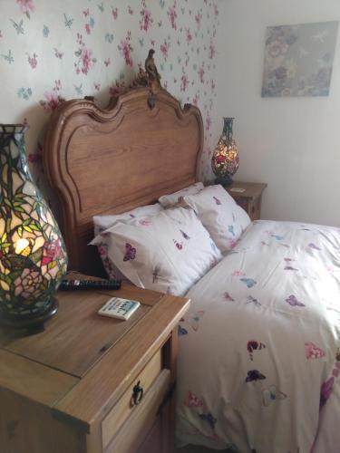 a bedroom with a bed and a nightstand with a bed sidx sidx at Llanwrtyd Hall B&B Angelis Holistic Retreat in Llanwrtyd Wells
