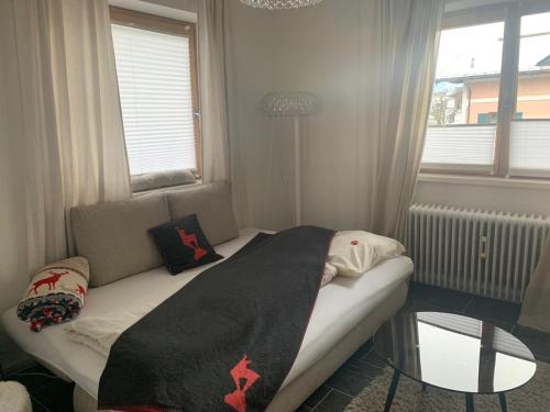 a small bedroom with a bed with a glass table at Hornhaus in Kitzbühel