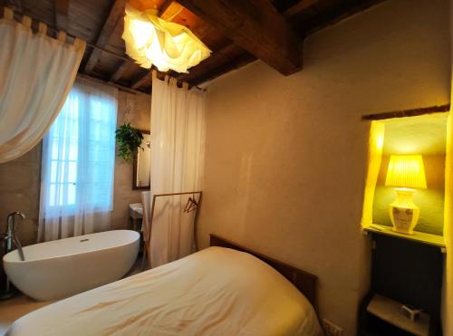 uma casa de banho com uma cama, uma banheira e um lavatório. em At Home in Arles em Arles