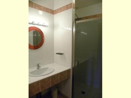 La salle de bains est pourvue d'un lavabo et d'une douche en verre. dans l'établissement Gîte de Minère, à Estang