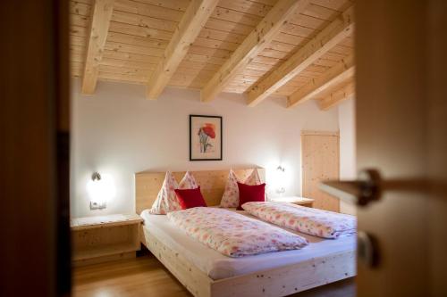 ein Schlafzimmer mit 2 Betten und roten Kissen darauf in der Unterkunft Apartments Obereggerhof in Vals