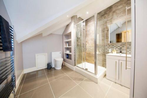 a bathroom with a shower and a toilet and a sink at Clifton Spacious 3 Bed Apt & Parking - Simplycheckin in Bristol