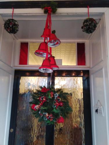 a christmas wreath and lights hanging over a door at Llanwrtyd Hall B&B Angelis Holistic Retreat in Llanwrtyd Wells