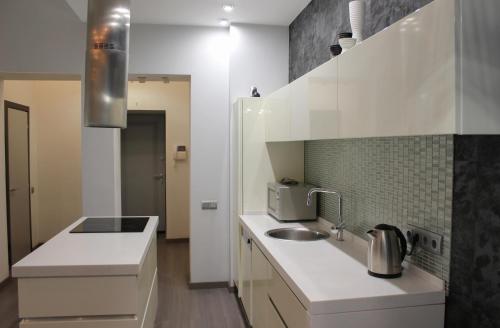 a white kitchen with a sink and a microwave at Central Area Apartments in Kyiv