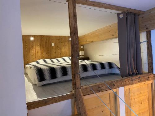 a bedroom with a bed on a wooden platform at La Grange Auguste avec Sauna Jacuzzi in Vénosc